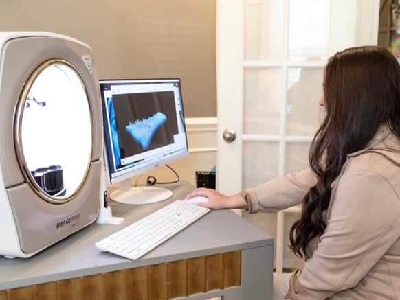 A woman moving a mouse on a computer.